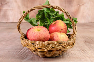 Apple and Asiatic in basket on wood background