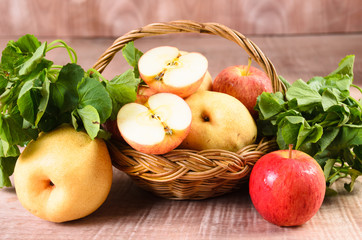 Apple and Asiatic in basket on wood background