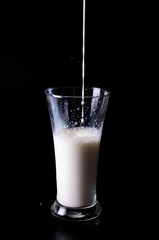 pouring a glass of milk creating splash