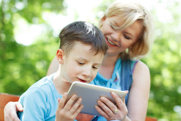 Happy mother and son with tablet