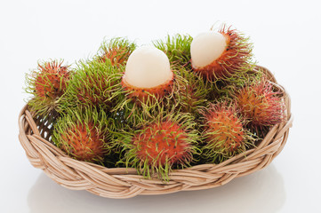 Basket of red hairy rambutan fruits.