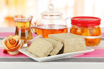 Tasty halva with tea on table in room