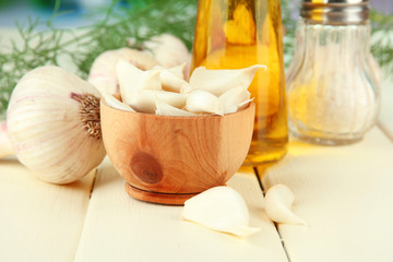 Fresh garlic on wooden table, on bright background