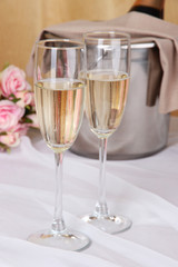 Champagne and glasses on round table on cloth background