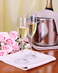Champagne and glasses on round table on cloth background
