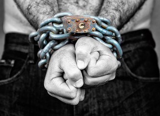 Man with his two hands chained