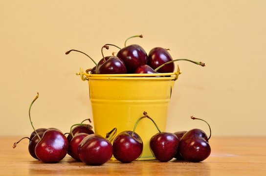 Red Cherries in a yellow bucket