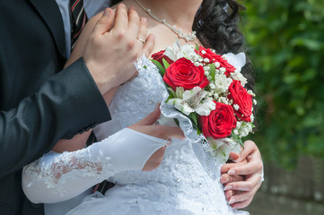 The groom embraces the bride