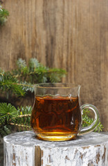 Glass of hot tea among christmas decorations