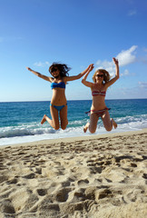Young women high jump on a beach