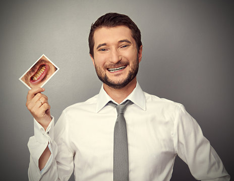 man holding picture with yellow teeth