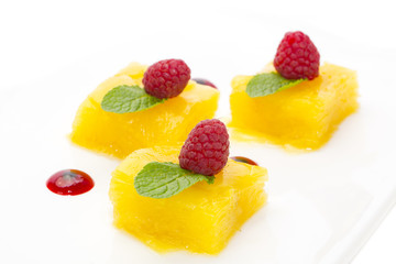 Dessert of pineapple and decorated with raspberries on a white background 