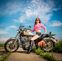 Fototapeta na wymiar Biker girl sitting on motorcycle