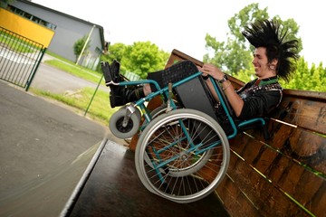 Fototapeta na wymiar Punk homme en fauteuil roulant faisant du sport