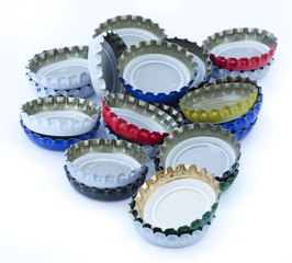 A stack of metal bottle caps isolated on white background.