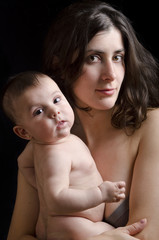 Mother and baby on dark background,low key portrait.