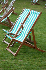 Wiese mit gr&uuml;n-wei&szlig; gestreiften Liegest&uuml;hlen