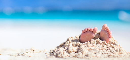 Obraz na płótnie Canvas Little feet covered with sand