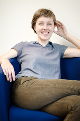 young beautiful hipster woman sitting in the armchair