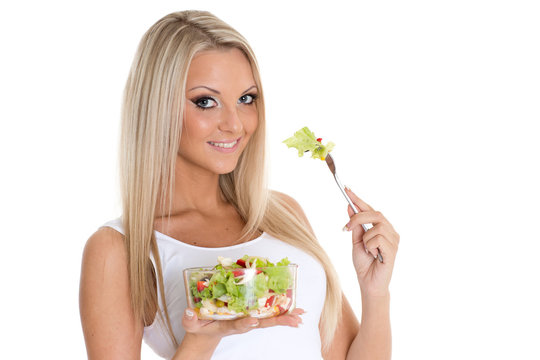 Slender woman holds a bowl of salad.