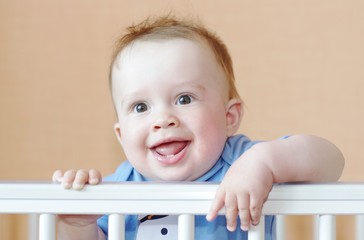 smiling happy baby in white bed