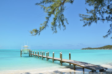 Fototapeta na wymiar Yacht at the wooden jetty. Exuma, Bahamas
