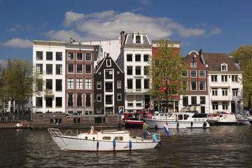Fototapeta na wymiar Amsterdam with motor boat on canal in Holland