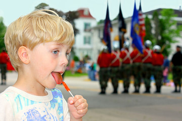Child Watching Parade and Eating Candy