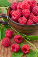 fresh raspberry in a cup on wooden table