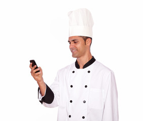 Charming guy in chef uniform texting on cellphone