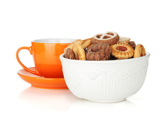 Various cookies in bowl and orange tea cup