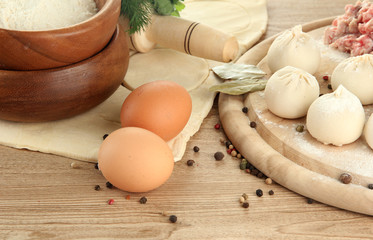 Raw dumplings, ingredients and dough, on wooden table