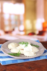 Tasty dumplings on plate, on wooden table