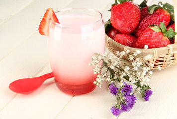 Delicious strawberry yogurt in glass on wooden table close-up