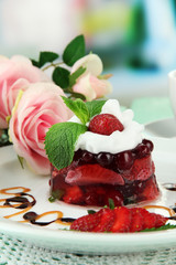 Tasty jelly dessert with fresh berries, on bright background