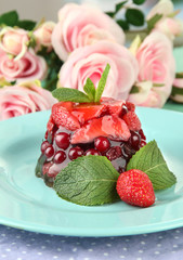 Tasty jelly dessert with fresh berries, on bright background