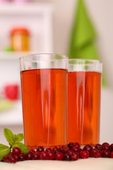 Glasses of cranberry juice and ripe red cranberries on table