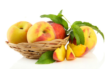 Naklejka na ściany i meble Ripe sweet peaches with leaves in basket, isolated on white