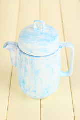 Antique white teapot on wooden table close-up