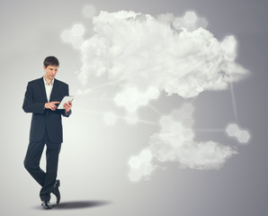 Businessman with touchscreen internet tablet and the clouds