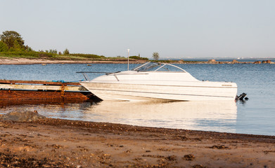 Motor boat parking aside rusty quay