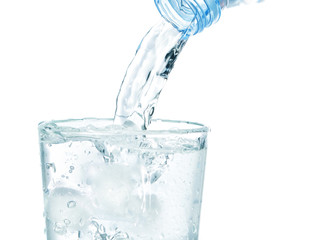 In a glass with ice flowing clean water. On a white background.