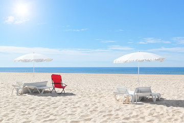 Sunny beach in Portugal with sunbeds and umbrellas. Summer.