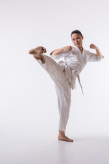 Beautiful woman in kimono show marshal art foot kick on white