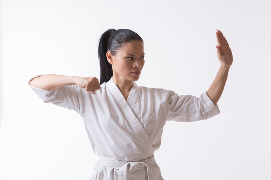 Beautiful woman in kimono show marshal art exercise on white