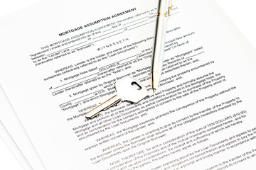 Mortgage assumption agreement with a pen for signature and a key