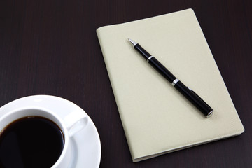 notebook with coffee cup on table