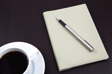 notebook with coffee cup on table