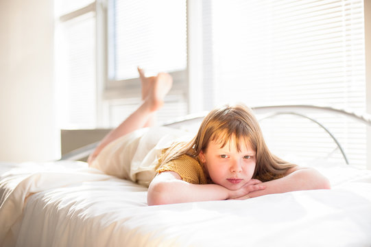 girl lying on the bed by the window