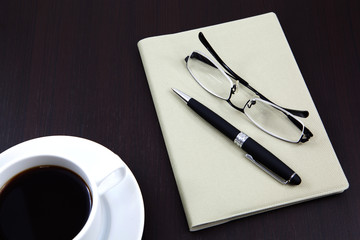 notebook with coffee cup on table